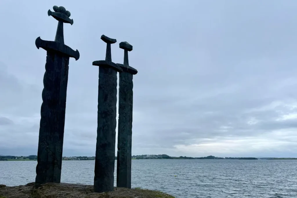 노르웨이 스타방에르 인근 해변에 세워진 ‘세 개의 검’ 조형물, 푸른 하늘과 바다를 배경으로 선 세 개의 거대한 철제 검