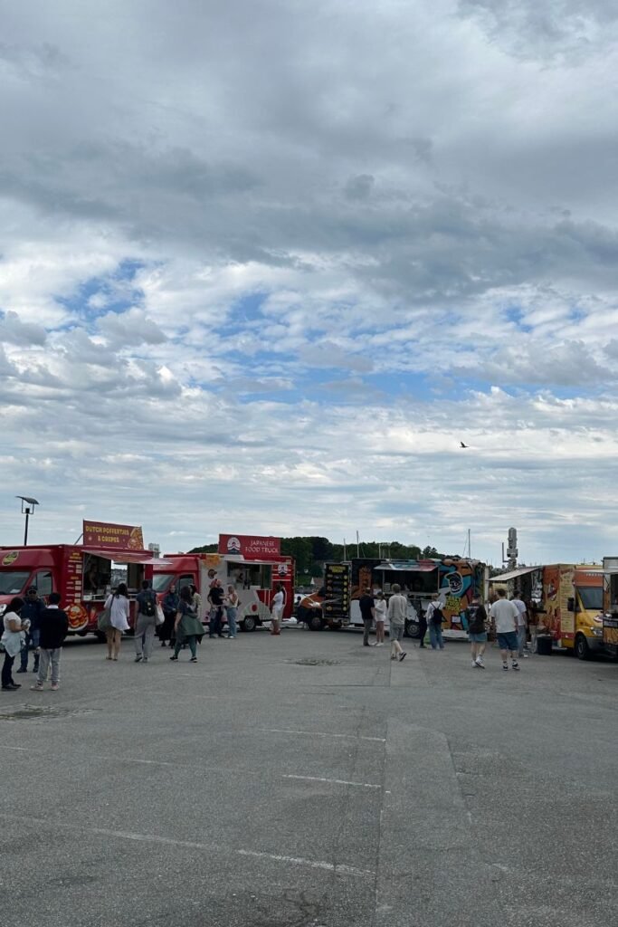 스타방에르 항구에 위치한 푸드트럭과 노천 테이블, 바다를 배경으로 한 현지 먹거리 풍경