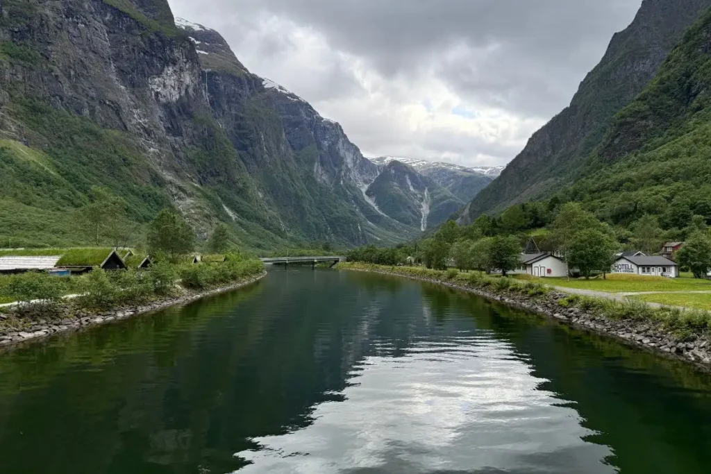 거대한 피오르드 절벽 아래 자리 잡은 노르웨이 구드방겐 마을의 평화로운 전경