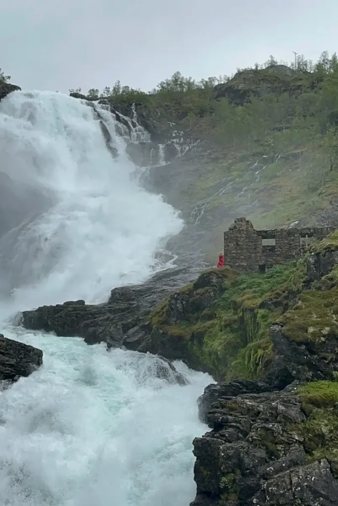 크요스포센 폭포 옆 바위 위에서 춤을 추고 있는 붉은 옷의 요정 훌드라