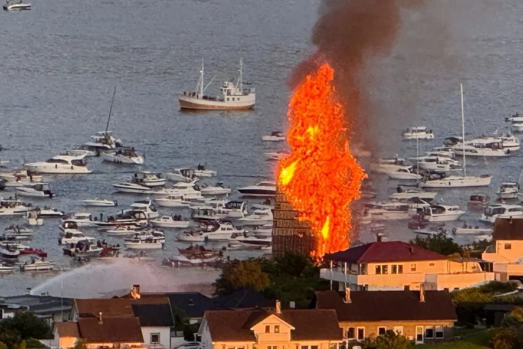 노르웨이 올레순의 밤하늘 아래, 거대한 슬리닝스볼렛 모닥불이 절정을 이루며 활활 타오르는 모습
