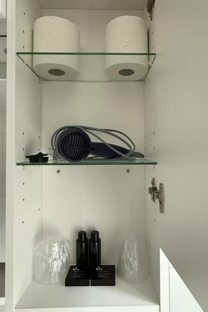 노르웨이 방스가르덴 호텔 욕실에 구비된 헤어 드라이어와 샴푸, 컨디셔너, 바디워시 어메니티.