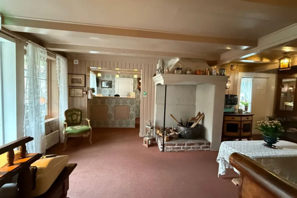 앤티크한 가구와 따뜻한 조명으로 꾸며진 노르웨이 방스가르덴 호텔 본관 1층의 아늑한 로비와 리셉션 공간.