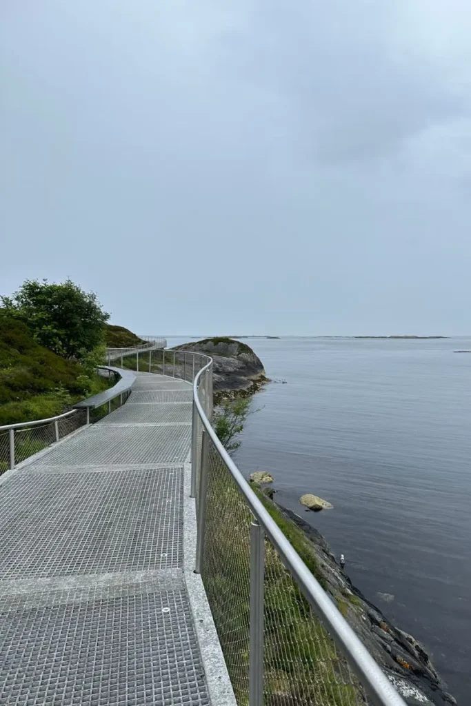 노르웨이 아틀란틱 로드 엘드후소이야(Eldhusøya) 섬에 설치된 '떠 있는 산책로(Float Walking Path)'. 거친 바위섬과 **피오르드** 해안 위를 부드러운 곡선으로 감싸며 이어지는 독특한 디자인의 산책로 전경.