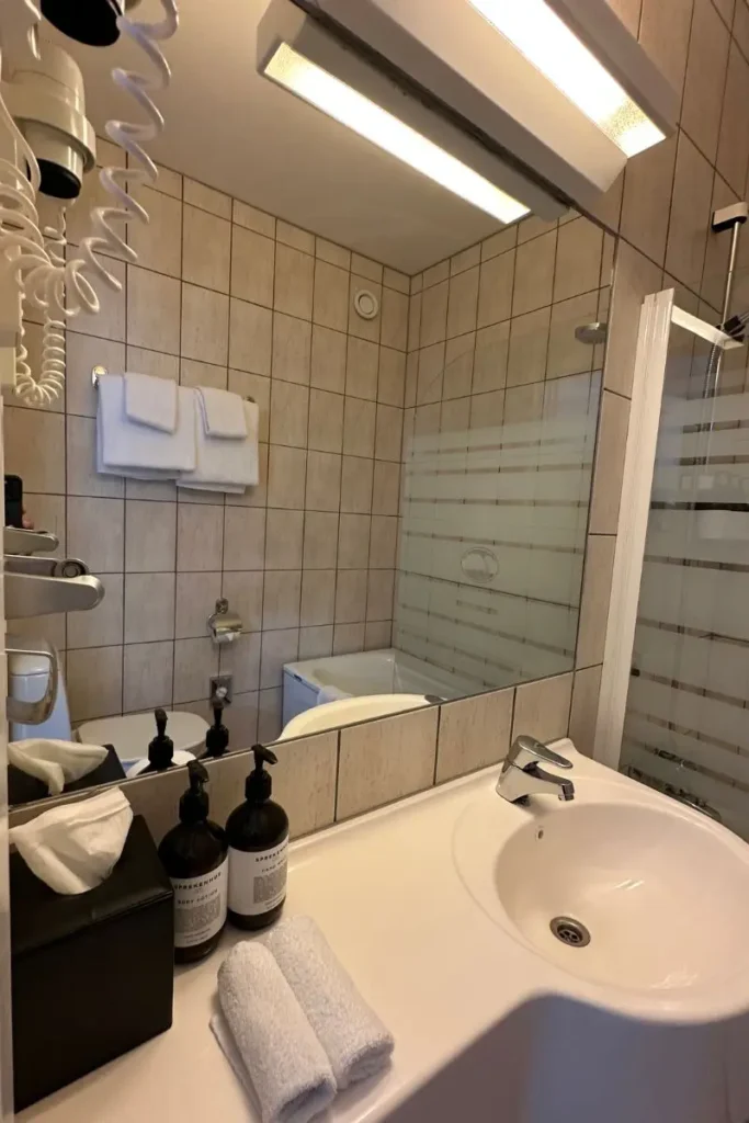 그란데 피오르드 호텔 욕실의 물기 없이 깨끗하게 청소된 현대식 세면대와 거울 모습