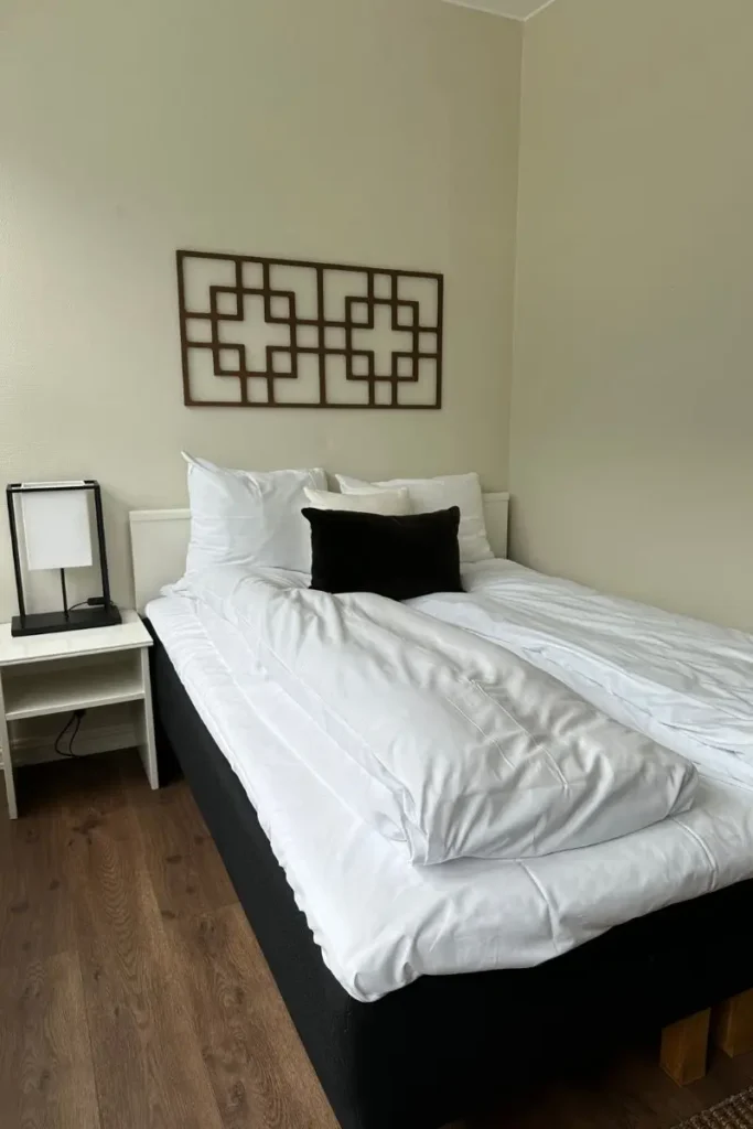 노르웨이 그란데 피오르드 호텔 객실의 깨끗하게 정돈된 흰색 침구와 더블 침대 모습